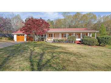 Charming home with a red metal roof, a covered front porch, and a well-manicured lawn at 6690 Pine Ridge Cir, Cumming, GA 30041
