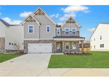 Charming two-story home with a brick and gray facade, spacious garage, and a welcoming front porch at 4212 Adler Cir, Buford, GA 30519