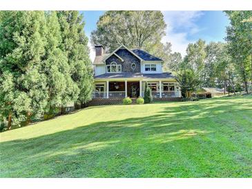 Charming two-story home with a welcoming front porch, manicured lawn, and mature trees at 2962 Norman Cir, Duluth, GA 30096