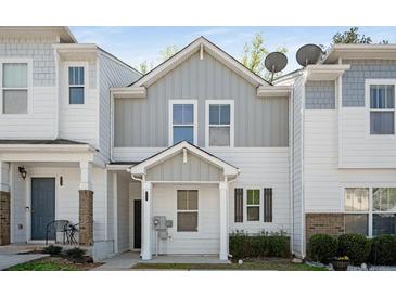 Charming townhouse featuring a modern white and gray exterior with a welcoming front porch at 4457 Watson Ridge Dr, Stone Mountain, GA 30083