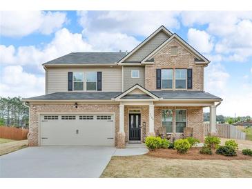 Charming two-story home with brick and siding, well-manicured lawn, and attached two car garage at 1105 Alaska St, Hampton, GA 30228