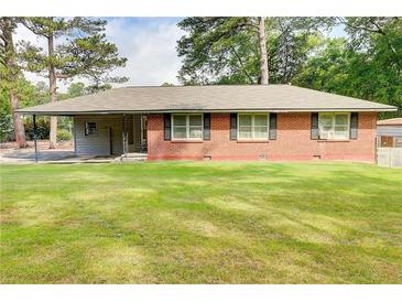 Charming single-story brick home with a well-maintained lawn, covered porch, and mature trees at 3221 Colquitt Dr, Atlanta, GA 30340