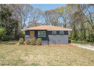 Charming single-story home featuring a cozy front porch and landscaped yard at 5085 Lake Dr, Forest Park, GA 30297