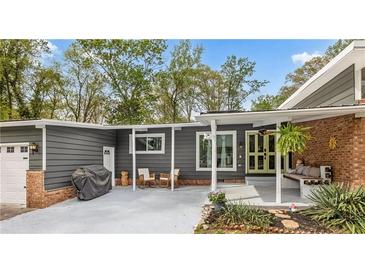 Stylish home exterior featuring gray siding, brick accents, covered porch, and well-maintained landscaping at 1185 Winterberry Ct, Lawrenceville, GA 30043