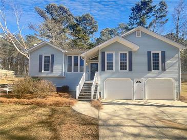 Charming light blue home with a two-car garage and steps leading to the front door at 3113 Shiloh Pl, Canton, GA 30115