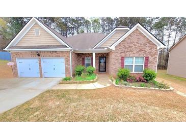 Charming brick home with a two-car garage and manicured landscaping at 113 Citadel Dr, Hampton, GA 30228
