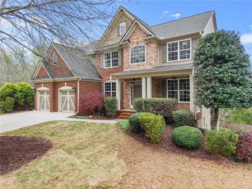 Charming two-story home with brick and stone accents, well-manicured landscaping, and a two-car garage at 5950 Bridge Stone Ct, Cumming, GA 30028