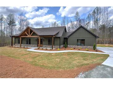 Charming home featuring a decorative wood gable, stone accents, and a welcoming walkway, set on a well-manicured lawn at 313 Morgan Rd, Temple, GA 30179
