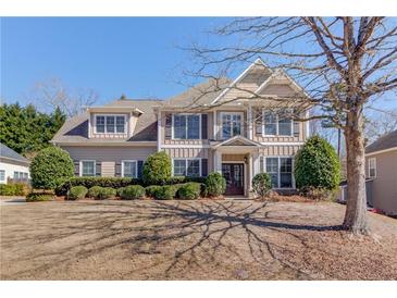 Charming two-story home with manicured lawn, complemented by lush landscaping and mature shade trees at 4155 Cami Way, Buford, GA 30519