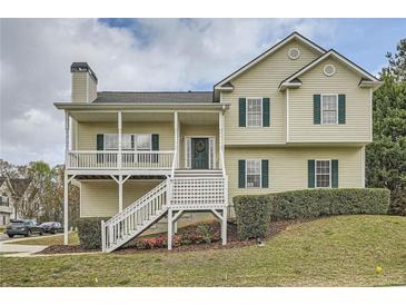 Charming two-story home with a welcoming front porch, manicured lawn, and classic curb appeal at 5997 Tate Dr, Austell, GA 30106