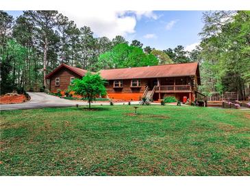 Charming log home with a well-manicured lawn and a welcoming front porch at 1791 Walker Sw Rd, Conyers, GA 30094