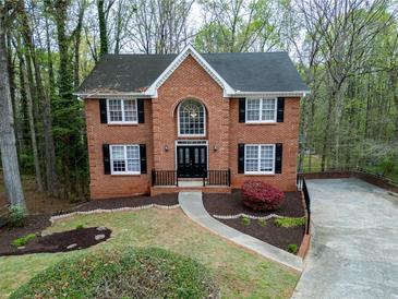 Charming brick home featuring a landscaped front yard and black-shuttered windows at 1810 Talbot Ct, Lawrenceville, GA 30044