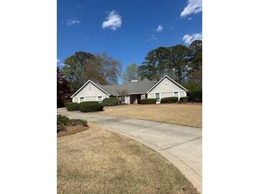 Charming single-story home with manicured lawn, driveway, and mature trees offering great curb appeal at 595 Willow Knoll Se Dr, Marietta, GA 30067