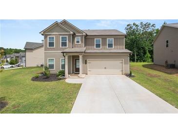 Charming two-story home with a well-manicured lawn and a two-car garage in a suburban neighborhood at 485 Auburn Crossing Dr, Auburn, GA 30011