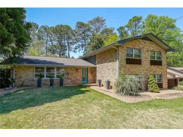 Charming two-story brick home featuring a well-manicured lawn and vibrant green trees at 3530 Embry Cir, Atlanta, GA 30341