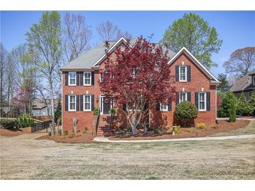 Charming two-story brick home featuring a manicured lawn and beautifully landscaped front yard at 880 Crossfire Nw Rdg, Marietta, GA 30064