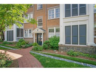 Brick condo building featuring well-maintained landscaping and inviting entrance with a brick walkway and manicured garden at 8 Collier Nw Rd # B2, Atlanta, GA 30309