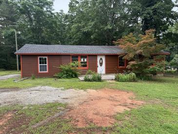 Cozy one story home with a yard featuring mature trees and an exterior with painted wood siding and trim at 144 Flat Rock Rd, Oxford, GA 30054