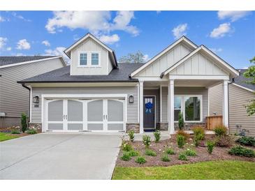 Charming home featuring a welcoming front porch, two-car garage, and beautiful landscaping at 5133 Aster Bnd, Canton, GA 30114