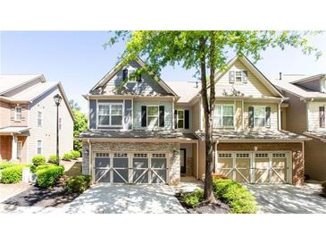 Charming townhome with stone accents, a two-car garage, and manicured landscaping at 5715 Keys Way, Lithonia, GA 30058