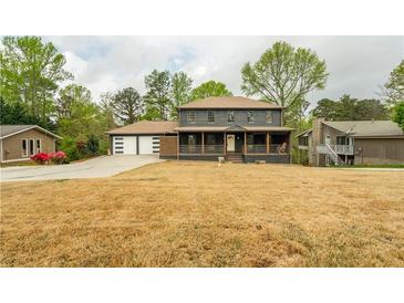 Charming two-story home featuring a welcoming front porch and an attached two-car garage at 5254 Greenpoint Dr, Stone Mountain, GA 30088