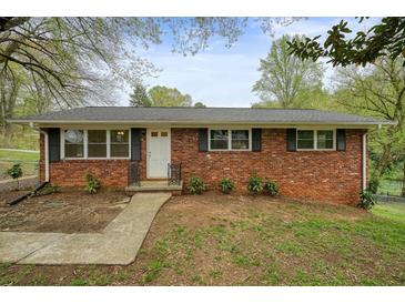 Charming one-story brick home with a manicured lawn and mature trees in a residential neighborhood at 281 Piedmont Ne Rd, Marietta, GA 30066
