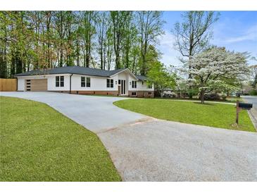 Beautifully renovated home featuring a long driveway and lush green lawn at 3805 Cloudland Se Dr, Smyrna, GA 30082