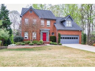 Charming two-story brick home with a well-manicured lawn and a bright red front door at 2739 Springfount Trl, Lawrenceville, GA 30043
