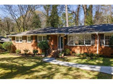 Charming brick home with a well-manicured lawn and mature landscaping at 3095 Meadow Lark Ln, Atlanta, GA 30344