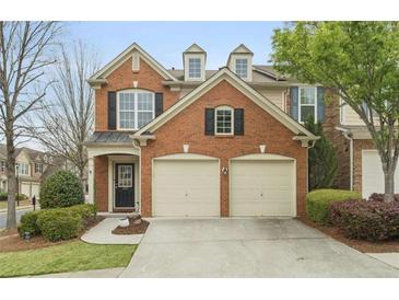 Charming red brick home featuring a two-car garage and manicured landscaping at 1680 Fair Oak Way # 24, Mableton, GA 30126