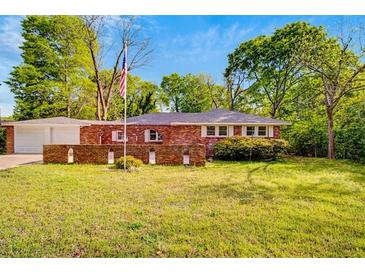 Charming red brick home with an expansive front lawn and inviting curb appeal at 1150 Tinsley Nw Dr, Conyers, GA 30012