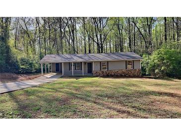 Charming single-story home featuring stone accents and a well-maintained lawn at 130 Fairview Dr, Stockbridge, GA 30281