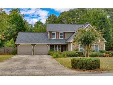 Charming home featuring a two-car garage, well-maintained landscaping, and a mix of stone and siding exterior at 3420 Sweetbriar Ln, Powder Springs, GA 30127