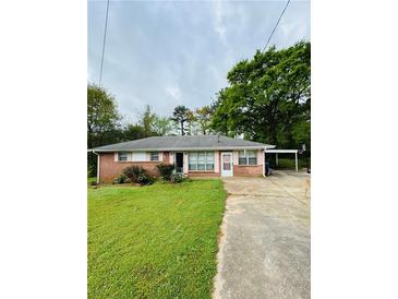 Charming one-story brick home featuring a well-maintained lawn and covered parking at 1145 Crestview Ne Cir, Conyers, GA 30012