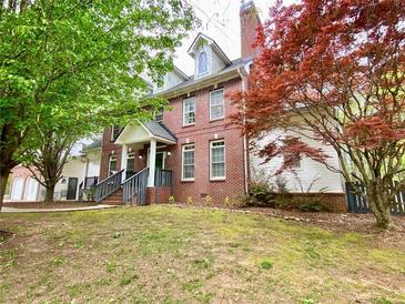 Beautiful brick home with a well-manicured lawn and mature trees at 2210 Holly Springs Rd, Rockmart, GA 30153