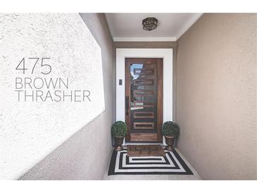 Inviting entryway featuring a modern wood door, sleek black and white rug, and stylish potted plants at 475 Brown Thrasher Ct, Alpharetta, GA 30009
