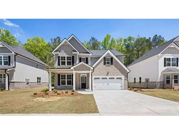 New construction home showcasing its manicured front yard, two-car garage, and brick accents at 13918 Homer Ln, Covington, GA 30014