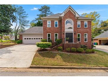 Charming two-story brick home with a well-manicured front yard and attached garage at 2804 Livsey Woods Dr, Tucker, GA 30084