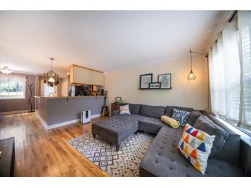 Inviting living room featuring a comfortable sectional sofa, stylish rug, and access to the adjacent kitchen at 2232 Dunseath Ave # 407, Atlanta, GA 30318