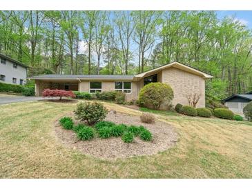 Charming single-story home featuring brick exterior, mature trees, and a well-maintained landscaped front yard at 1478 Biltmore Ne Dr, Atlanta, GA 30329