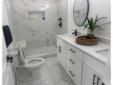 Modern bathroom features sleek white marble tile, a spacious walk-in shower, and elegant black fixtures at 1841 Bayberry Sw Dr, Atlanta, GA 30311