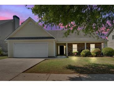 Charming single-story home featuring a well-manicured lawn, attached garage, and mature trees at 2793 Saddle Horn, Snellville, GA 30039