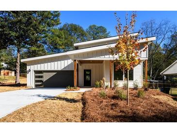 Charming modern home featuring sleek design, gray garage door, and tasteful landscaping at 2526 Abner Nw Pl, Atlanta, GA 30318