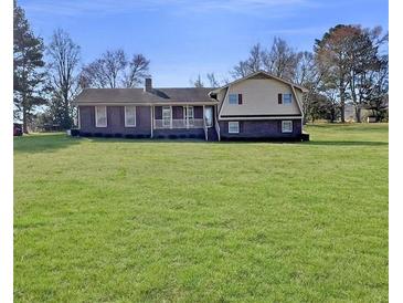 Charming brick home with a sprawling green lawn and inviting front porch at 3415 Spot Rd, Cumming, GA 30040