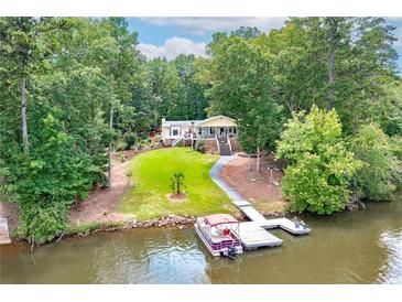 Lakefront home with a private dock and lush green lawn stretching to the water's edge at 590 Yancey Cir, Covington, GA 30014