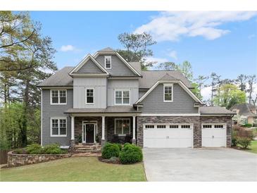Charming two-story home with stone accents, three-car garage, well-manicured lawn, and lush landscaping at 2811 Shady Valley Ne Dr, Brookhaven, GA 30324