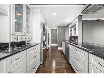 Modern kitchen features sleek white cabinetry, stainless steel appliances, and black marble countertops at 3435 Kingsboro Ne Rd # 603, Atlanta, GA 30326
