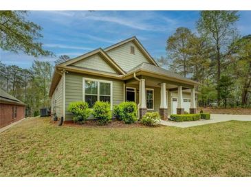 Charming craftsman-style home with green siding, well-manicured lawn, and inviting front porch at 9117 Dearing St, Covington, GA 30014