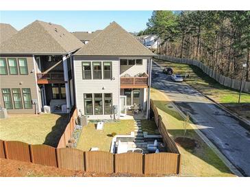A fenced backyard offers a patio and a fire pit sitting area, providing comfortable outdoor living space at 158 Village Green Ave, Woodstock, GA 30189
