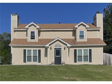 Charming two-story home features a well-manicured lawn and inviting front porch at 1174 Oak Knoll Ct, Lithonia, GA 30058
